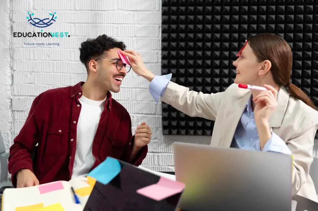 A man and woman enjoy a lively moment at a desk, employee development fun and engaging activities.