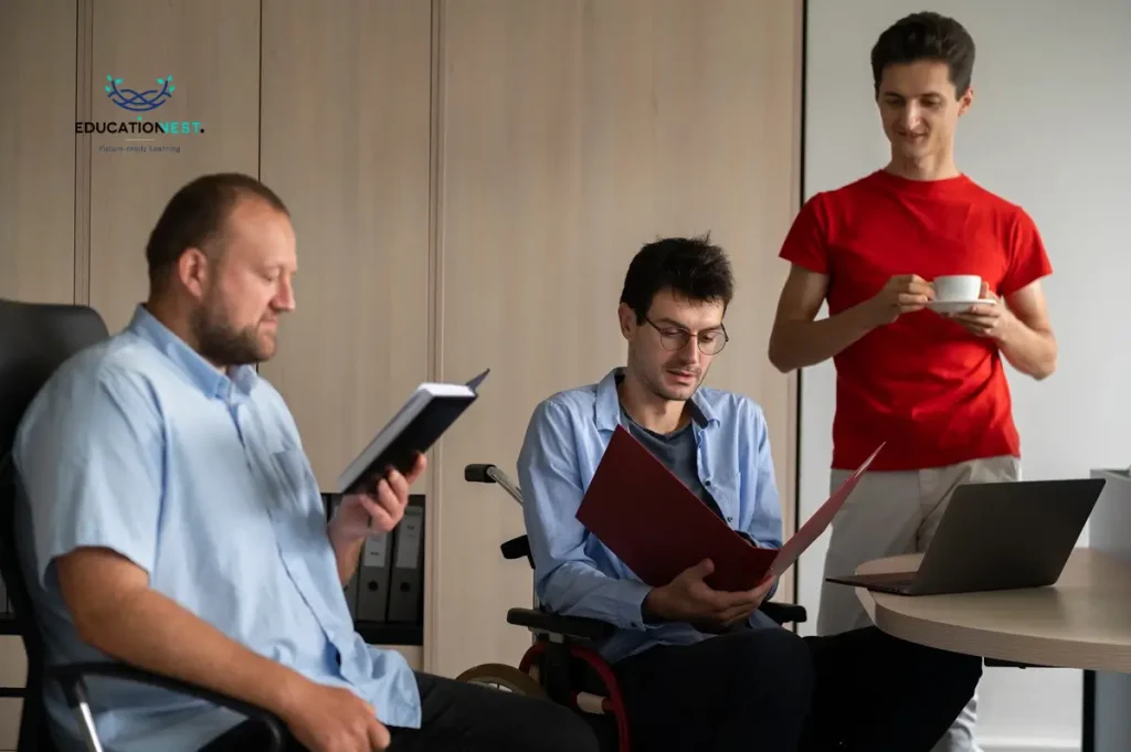 Three men at a table with a laptop and coffee, symbolizing collaboration and learning to boost employee engagement and well-being.