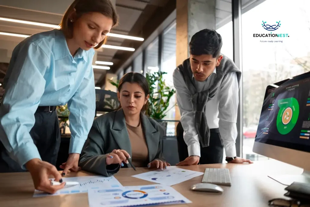  A trio of business individuals focused on a computer screen, exploring key employee development trends for 2025.