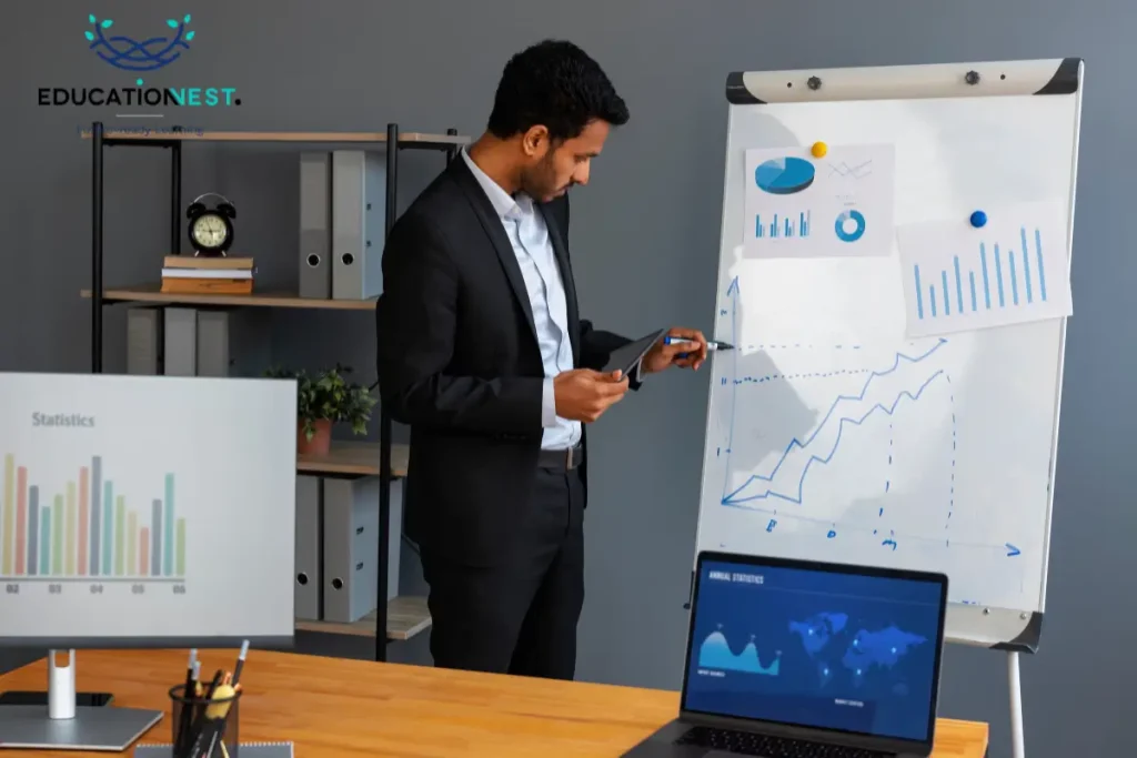 A man in a suit works on a laptop beside a whiteboard, illustrating effective sales techniques in India.