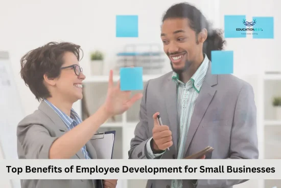 Two business professionals discussing employee development strategies in front of a wall covered with colorful sticky notes.