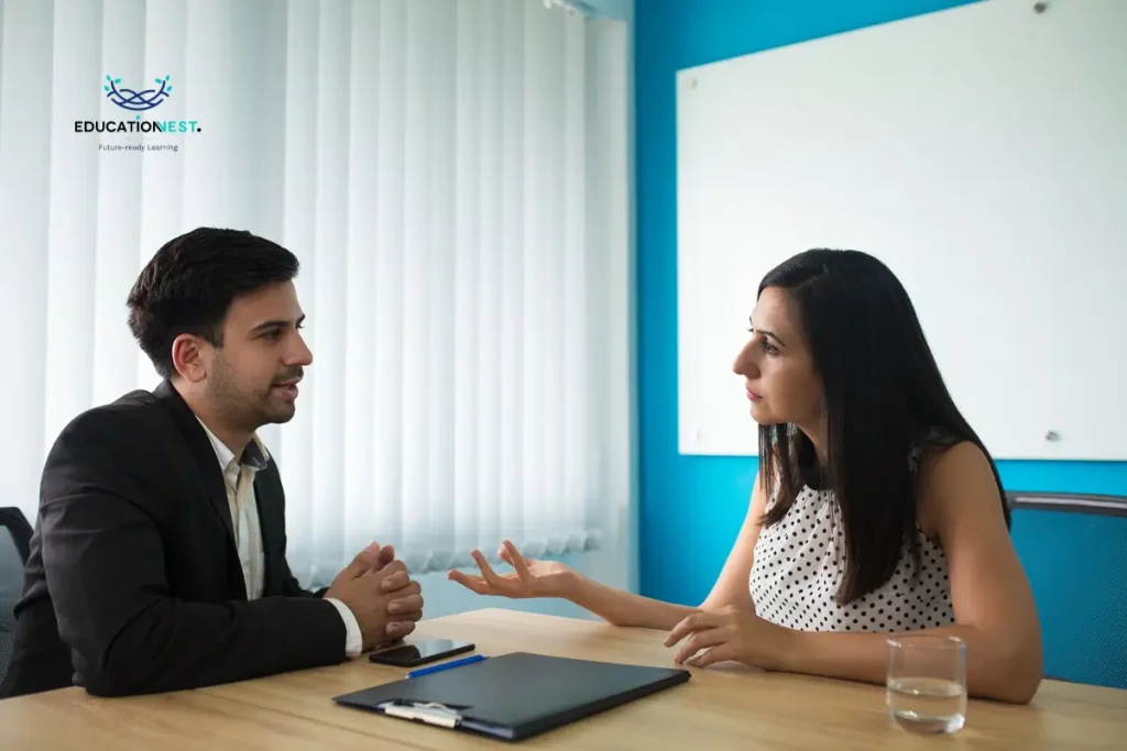 A man and woman in business attire converse at a table, focusing on strategies for building long-term client relationships.