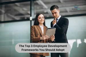 Two business professionals discussing the Top 3 Employee Development Frameworks, reviewing strategies on a tablet in a modern office setting.