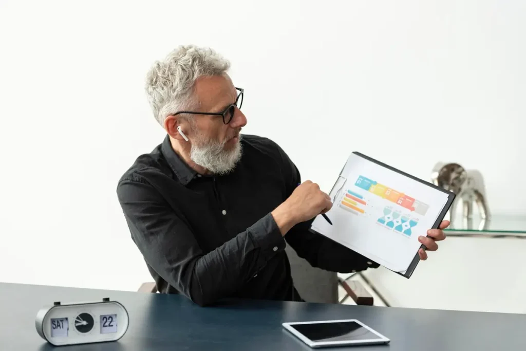 A man with a beard and glasses analyzes a performance chart on a tablet, representing Rational Performance Tester.