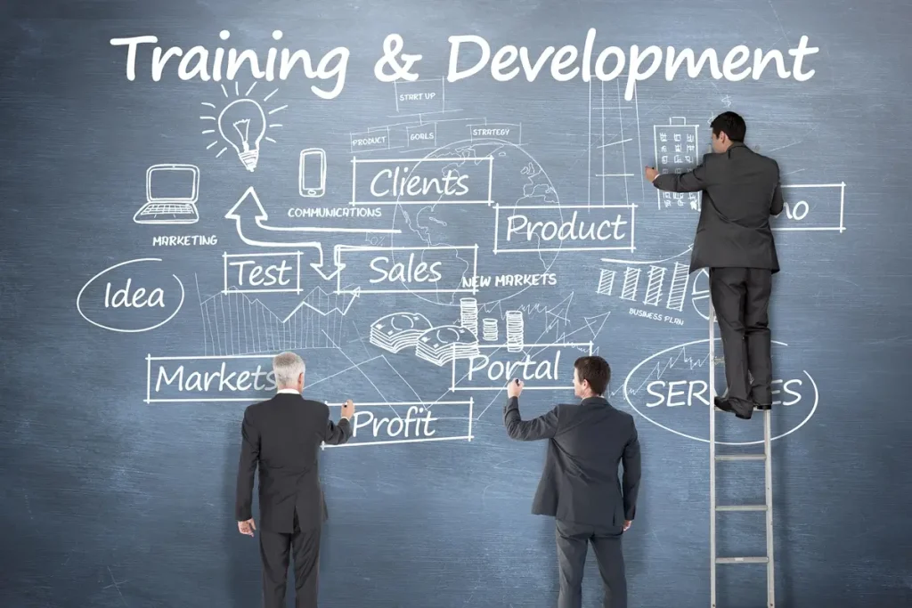 Business professionals on a ladder, discussing a training diagram for Soft Skills Training Topics on a blackboard.